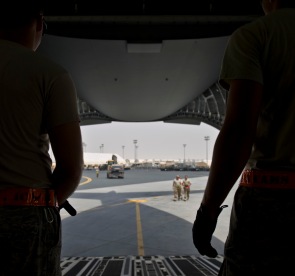 Airmen from the 8th Expeditionary Air Mobility Squadron prepare as an excavator is brought on board a C-17 Globemaster III at the 379th Air Expeditionary Wing in Southwest Asia, July 17, 2013. The C-17 will fly the heavy equipment to a forward operating location in Afghanistan where 1st Expeditionary Civil Engineer Group units will use it to support ongoing Operation Enduring Freedom missions. (U.S. Air Force photo/Senior Airman Benjamin Stratton)